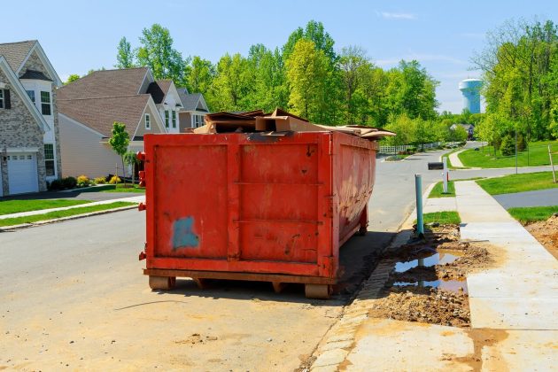 Large red roll-off container for residential dumpster waste disposal