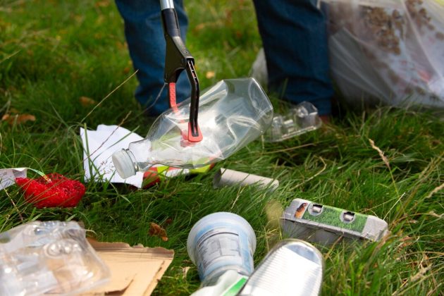 Volunteer picking up litter during community yard waste removal project