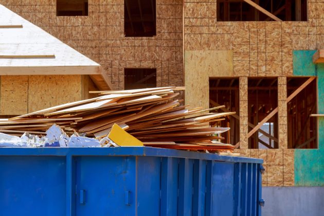 Plywood scraps piled in container for home renovation dumpster rental