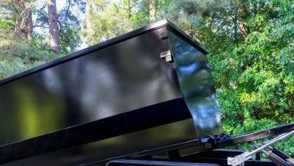 Enclosed roll off container or dumpster on delivery truck bed